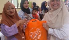 Petugas Dinas Perikanan Kabupaten Bekasi membagikan ikan kepada warga dalam program peningkatan konsumsi ikan untuk pencegahan stunting.