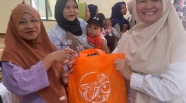 Petugas Dinas Perikanan Kabupaten Bekasi membagikan ikan kepada warga dalam program peningkatan konsumsi ikan untuk pencegahan stunting.