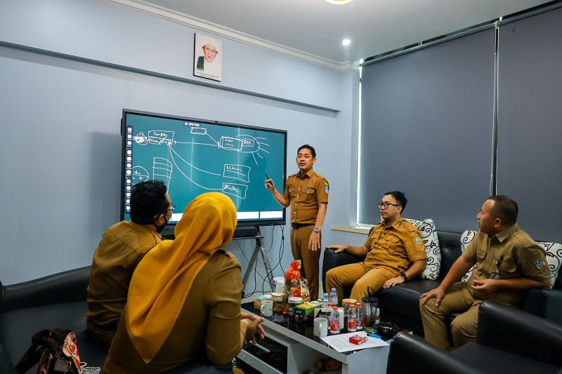 Sejumlah aparatur Pemerintah Kabupaten Bekasi mengikuti rapat koordinasi terkait penguatan layanan teknologi informasi di ruang kerja, dengan pemaparan materi menggunakan layar digital, Selasa (7/4/2026).