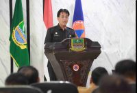 Asisten Pemerintahan dan Kesejahteraan Rakyat Setda Kabupaten Bekasi, Hudaya, menyampaikan sambutan Plt Bupati Bekasi dalam rapat koordinasi penyelenggaraan pemerintahan desa di Aula BPBD Kabupaten Bekasi, Selasa (14/4/2026).