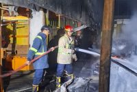 Petugas Dinas Pemadam Kebakaran Kabupaten Bekasi berupaya memadamkan kobaran api yang melanda Gedung Pasar Ramayana pada Minggu malam (17/5/2026). Kebakaran diduga dipicu korsleting listrik dan menghanguskan sedikitnya tujuh lapak pedagang.