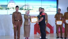 Plt Bupati Bekasi Asep Surya Atmaja menyerahkan penghargaan kepada pemerintah desa dan BUMDes berprestasi dalam Workshop Evaluasi Pengelolaan Keuangan dan Pembangunan Desa Tahun 2026 di Gedung Swatantra Wibawa Mukti, Kompleks Pemkab Bekasi, Selasa (5/5/2026).