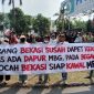 Ratusan warga yang tergabung dalam kelompok Masyarakat Bekasi Peduli Gizi Anak Bangsa menggelar aksi damai di kawasan Bekasi International Industrial Estate (BIIE), Cikarang Selatan, Kabupaten Bekasi, Sabtu (20/6/2026).