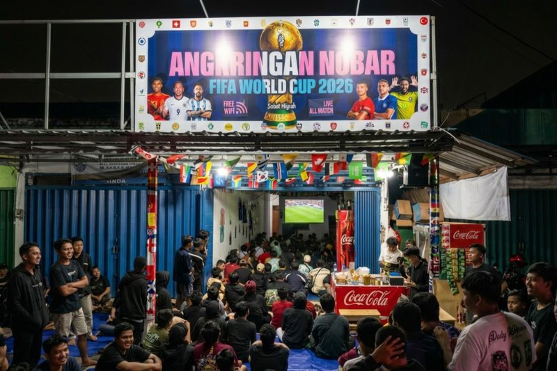 Pengunjung memadati Angkringan Nobar di kawasan Sesetan, Bali, untuk menyaksikan pertandingan Piala Dunia 2026. Kebijakan TVRI yang menggratiskan lisensi nobar resmi dinilai membantu pelaku UMK sekaligus menghadirkan ruang kebersamaan bagi masyarakat pecinta sepak bola. (Foto: Istimewa)