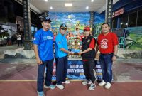Kepala Bidang Pencegahan BNK Kabupaten Bekasi, Susilo Budiyanto (dua dari kiri), menyerahkan trofi kepada perwakilan panitia Turnamen Bulutangkis HANI 2026 yang digelar di Perumahan Villa Bekasi Indah I RW 12, Tambun Selatan, Sabtu (27/6/2026) malam. Turnamen diikuti 53 peserta dari 17 RT sebagai bagian dari kampanye