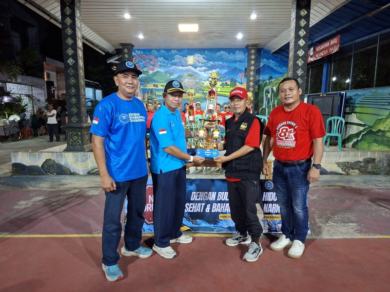 Kepala Bidang Pencegahan BNK Kabupaten Bekasi, Susilo Budiyanto (dua dari kiri), menyerahkan trofi kepada perwakilan panitia Turnamen Bulutangkis HANI 2026 yang digelar di Perumahan Villa Bekasi Indah I RW 12, Tambun Selatan, Sabtu (27/6/2026) malam. Turnamen diikuti 53 peserta dari 17 RT sebagai bagian dari kampanye 