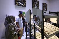 Pengunjung melihat dan mencoba koleksi kacamata branded di salah satu booth optik saat gelaran Jakarta Fair Kemayoran 2026. Beragam promo menarik, termasuk diskon hingga 90 persen, menjadi daya tarik bagi masyarakat.