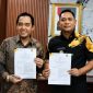 Plt Bupati Bekasi, dr. Asep Surya Atmaja (kanan), bersama Kepala BPJS Kesehatan Cabang Cikarang, Erwin Fadillah, menunjukkan dokumen addendum kerja sama Program Jaminan Kesehatan Nasional (JKN) usai penandatanganan di Kompleks Pemkab Bekasi, Rabu (1/7/2026).