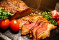 Irisan daging panggang premium dengan tingkat kematangan sempurna tersaji hangat, menampilkan tekstur juicy di bagian dalam dan lapisan luar yang karamelisasi, dilengkapi garnish tomat ceri dan sayuran segar—menggugah selera dalam sajian Asian Barbecue Feast di Harper Cikarang.