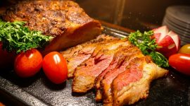 Irisan daging panggang premium dengan tingkat kematangan sempurna tersaji hangat, menampilkan tekstur juicy di bagian dalam dan lapisan luar yang karamelisasi, dilengkapi garnish tomat ceri dan sayuran segar—menggugah selera dalam sajian Asian Barbecue Feast di Harper Cikarang.