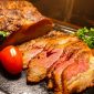Irisan daging panggang premium dengan tingkat kematangan sempurna tersaji hangat, menampilkan tekstur juicy di bagian dalam dan lapisan luar yang karamelisasi, dilengkapi garnish tomat ceri dan sayuran segar—menggugah selera dalam sajian Asian Barbecue Feast di Harper Cikarang.