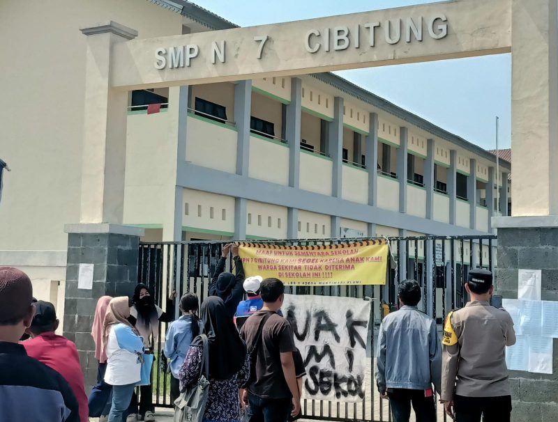 Warga Desa Muktiwari memasang spanduk dan melakukan penyegelan sementara gerbang SMP Negeri 7 Cibitung sebagai bentuk protes atas terbatasnya kuota penerimaan peserta didik baru. Mereka mendesak pemerintah segera menambah rombongan belajar agar seluruh calon siswa dapat tertampung.
