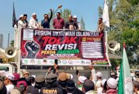 Anggota Pansus 14 DPRD Kabupaten Bekasi, Ombi Hari Wibowo bersama anggota pansus lainnya menemui massa Forum Ukhuwah Islamiyah (FUKIS) yang menggelar aksi di depan Gedung DPRD Kabupaten Bekasi, Kamis (9/7/2026). Audiensi tersebut menghasilkan kesepakatan untuk menunda sementara pembahasan Raperda Penyelenggaraan Kepariwisataan guna mengakomodasi aspirasi FUKIS, termasuk mempertahankan substansi Pasal 47 Perda Nomor 3 Tahun 2016.