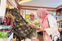 Ketua Dekranasda Kota Bekasi, Wiwiek Hargono, meninjau salah satu produk batik unggulan binaan UMKM Kota Bekasi saat mengikuti pameran HUT ke-46 Dewan Kerajinan Nasional (Dekranas) di Trans Studio Mall Makassar, Sulawesi Selatan, Jumat (10/7/2026). Delapan brand lokal Kota Bekasi tampil dalam ajang nasional tersebut sebagai upaya memperluas pasar dan meningkatkan daya saing produk kerajinan daerah. (Foto: Dok. Pemkot Bekasi)