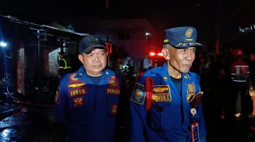 Komandan Pleton (Danton) Damkar Kabupaten Bekasi, Wawan (kanan), didampingi petugas Damkar Subur (kiri), memberikan keterangan kepada awak media usai memimpin proses pemadaman kebakaran empat kios di Pasar Tambun Selatan, Kabupaten Bekasi, Selasa (14/7/2026) malam. Kebakaran berhasil dipadamkan dalam waktu sekitar 20 menit tanpa menimbulkan korban jiwa.
