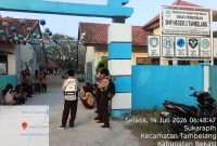 Suasana di pintu masuk SMP Negeri 2 Tambelang, Kecamatan Tambelang, Kabupaten Bekasi, Selasa (14/7/2026). Sejumlah wali murid menyoroti kondisi sarana dan prasarana sekolah yang dinilai masih memerlukan perhatian, di antaranya halaman sekolah yang masih berupa tanah serta sebagian pagar yang disebut belum memadai.