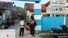Suasana di pintu masuk SMP Negeri 2 Tambelang, Kecamatan Tambelang, Kabupaten Bekasi, Selasa (14/7/2026). Sejumlah wali murid menyoroti kondisi sarana dan prasarana sekolah yang dinilai masih memerlukan perhatian, di antaranya halaman sekolah yang masih berupa tanah serta sebagian pagar yang disebut belum memadai.