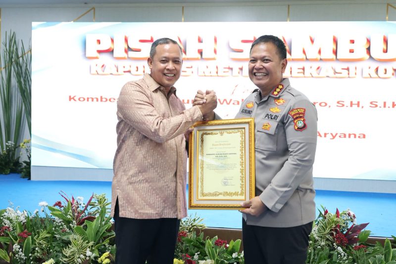 Wali Kota Bekasi Tri Adhianto menyerahkan cendera mata kepada Kombes Pol. Kusumo Wahyu Bintoro dalam acara pisah sambut Kapolres Metro Bekasi Kota, Jumat (31/7/2026). Kombes Pol. Kusumo mendapat penugasan baru sebagai Kabagsumda Rorenmin Baintelkam Polri.