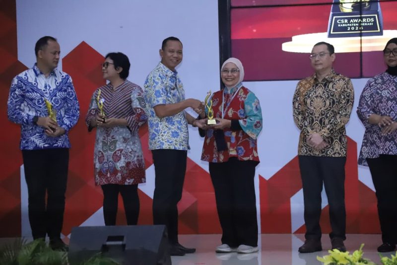 Sekretaris Daerah Kabupaten Bekasi Endin Samsudin menyerahkan penghargaan kepada salah satu penerima CSR Award Kabupaten Bekasi 2026 di Gedung Swatantra Wibawamukti, Cikarang Pusat, Kamis (2/7/2026). Penghargaan diberikan kepada perusahaan dan mitra yang dinilai berkontribusi terhadap pembangunan dan kesejahteraan masyarakat. FOTO: Endar Bachtiar/Diskominfosantik.