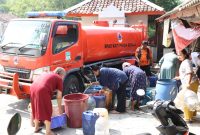 Warga Kampung Cihanjuang, Desa Ridogalih, Kecamatan Cibarusah, mengantre mengisi jeriken dan penampung air dari mobil tangki BPBD Kabupaten Bekasi. Sebanyak 10 ribu liter air bersih disalurkan untuk membantu ratusan keluarga yang terdampak kekeringan selama musim kemarau. Foto: Humas Pemkab Bekasi.