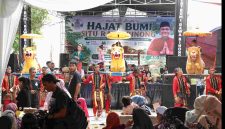 Warga menyaksikan pertunjukan seni budaya dalam rangka Hajat Bumi Situ Rawabinong di Desa Hegarmukti, Kecamatan Cikarang Pusat, Kabupaten Bekasi, Sabtu (11/7/2026).