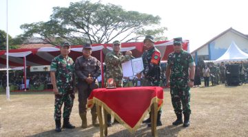 Plt. Bupati Bekasi dr. Asep Surya Atmaja menyerahkan dokumen Program TNI Manunggal Membangun Desa (TMMD) ke-129 kepada unsur TNI saat upacara pembukaan TMMD Tahun Anggaran 2026 di Lapangan Kecamatan Cibarusah, Kabupaten Bekasi, Selasa (15/7/2026). Program ini bertujuan mempercepat pemerataan pembangunan dan meningkatkan kesejahteraan masyarakat, khususnya di wilayah selatan Kabupaten Bekasi.