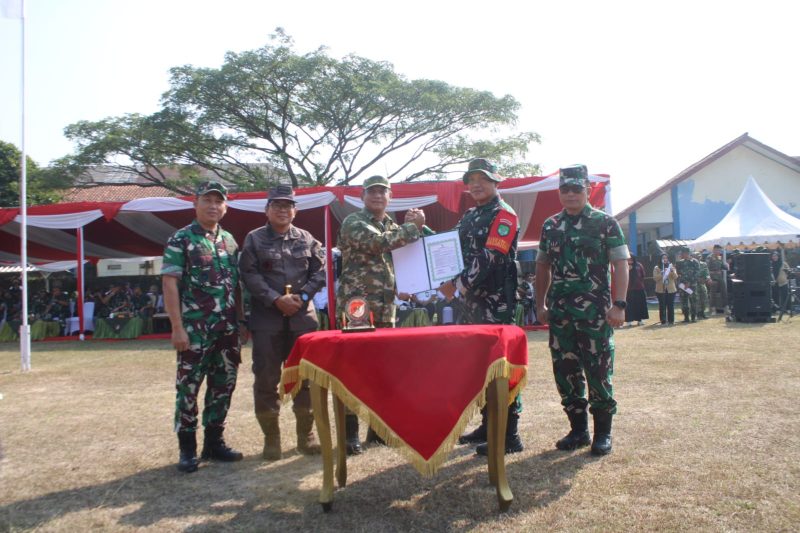 Plt. Bupati Bekasi dr. Asep Surya Atmaja menyerahkan dokumen Program TNI Manunggal Membangun Desa (TMMD) ke-129 kepada unsur TNI saat upacara pembukaan TMMD Tahun Anggaran 2026 di Lapangan Kecamatan Cibarusah, Kabupaten Bekasi, Selasa (15/7/2026). Program ini bertujuan mempercepat pemerataan pembangunan dan meningkatkan kesejahteraan masyarakat, khususnya di wilayah selatan Kabupaten Bekasi.