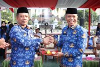 Sekretaris Daerah Kabupaten Bekasi, Endin Samsudin (kanan), menerima potongan tumpeng usai memimpin upacara peringatan Hari Koperasi Nasional (Harkopnas) ke-79 yang dirangkaikan dengan upacara Korpri bulanan di Plaza Pemerintah Kabupaten Bekasi, Senin (17/7/2026). Peringatan tersebut menjadi momentum memperkuat peran koperasi sebagai penggerak ekonomi kerakyatan di Kabupaten Bekasi.