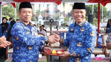 Sekretaris Daerah Kabupaten Bekasi, Endin Samsudin (kanan), menerima potongan tumpeng usai memimpin upacara peringatan Hari Koperasi Nasional (Harkopnas) ke-79 yang dirangkaikan dengan upacara Korpri bulanan di Plaza Pemerintah Kabupaten Bekasi, Senin (17/7/2026). Peringatan tersebut menjadi momentum memperkuat peran koperasi sebagai penggerak ekonomi kerakyatan di Kabupaten Bekasi.