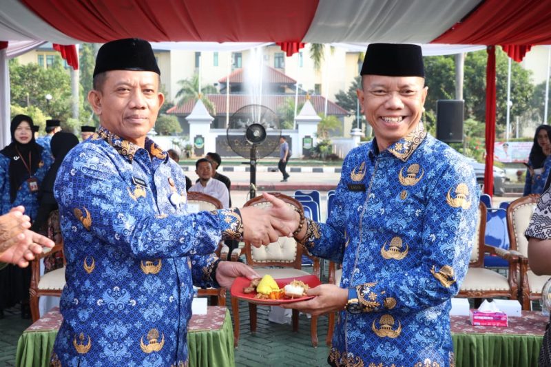 Sekretaris Daerah Kabupaten Bekasi, Endin Samsudin (kanan), menerima potongan tumpeng usai memimpin upacara peringatan Hari Koperasi Nasional (Harkopnas) ke-79 yang dirangkaikan dengan upacara Korpri bulanan di Plaza Pemerintah Kabupaten Bekasi, Senin (17/7/2026). Peringatan tersebut menjadi momentum memperkuat peran koperasi sebagai penggerak ekonomi kerakyatan di Kabupaten Bekasi.