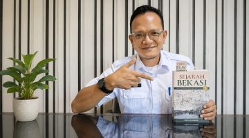 Penulis sekaligus sejarawan Bekasi, Endra Kusnawan, menunjukkan buku Sejarah Bekasi: Sejak Peradaban Buni Ampe Wayah Gini edisi ketiga yang kini menjadi salah satu koleksi unggulan Perpustakaan Daerah Kabupaten Bekasi. Buku setebal sekitar 600 halaman tersebut mengulas perjalanan sejarah Bekasi sejak Peradaban Buni hingga perkembangan pemerintahan modern. Foto: Istimewa