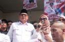 Haji Bahrudin, S.E. didampingi istri menyampaikan sambutan di hadapan ribuan pendukung usai resmi mendaftarkan diri sebagai bakal calon Kepala Desa Muktiwari periode 2026–2034 di Sekretariat Panitia Pilkades, Minggu (2/8/2026).