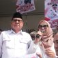 Haji Bahrudin, S.E. didampingi istri menyampaikan sambutan di hadapan ribuan pendukung usai resmi mendaftarkan diri sebagai bakal calon Kepala Desa Muktiwari periode 2026–2034 di Sekretariat Panitia Pilkades, Minggu (2/8/2026).