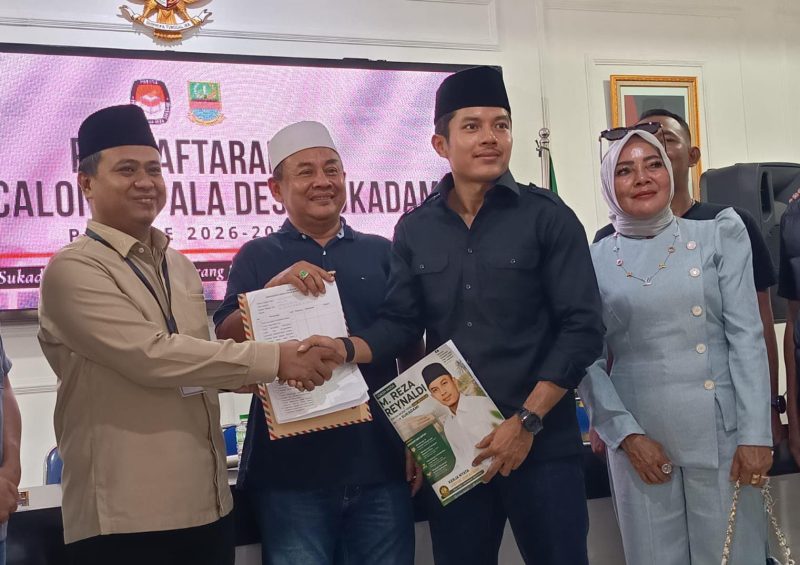M. Reza Reynaldi saat menyerahkan berkas pendaftaran bakal calon Kepala Desa Sukadami kepada Ketua Panitia Pilkades Sukadami Muhamad Muslihin, M.Ag., Minggu (2/8/2026).