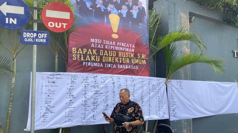 Spanduk mosi tidak percaya terhadap Direktur Umum Perumda Tirta Bhagasasi terpasang di area kantor perusahaan, disertai lembar tanda tangan yang diklaim sebagai dukungan dari sejumlah pegawai.