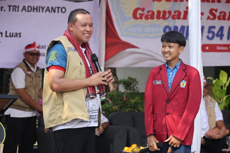 Wali Kota Bekasi Tri Adhianto berbincang dengan salah satu siswa SMPN 54 Kota Bekasi dalam kegiatan bakti sosial pemeriksaan kesehatan mata dan pembagian 300 kacamata, Selasa (11/8/2026). Kegiatan tersebut digelar Pemkot Bekasi bersama IROPIN untuk mendukung kenyamanan siswa dalam mengikuti proses pembelajaran.