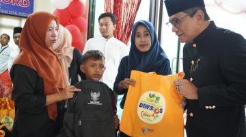 Kepala Dinas Sosial Kabupaten Bekasi, dr. Alamsyah, menyerahkan bantuan kepada salah satu peserta sunatan massal dalam rangkaian peringatan Hari Jadi Kabupaten Bekasi ke-76 di Poliklinik Pemda Kabupaten Bekasi, Sabtu (15/8/2026).