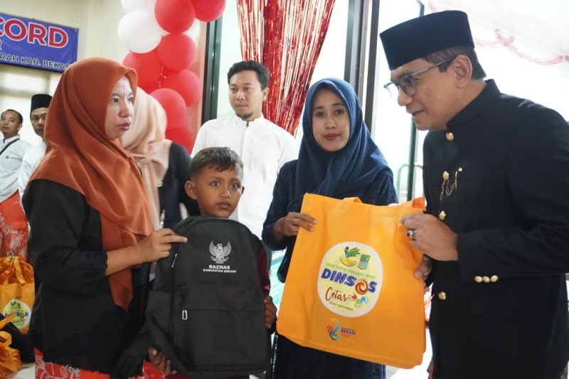 Kepala Dinas Sosial Kabupaten Bekasi, dr. Alamsyah, menyerahkan bantuan kepada salah satu peserta sunatan massal dalam rangkaian peringatan Hari Jadi Kabupaten Bekasi ke-76 di Poliklinik Pemda Kabupaten Bekasi, Sabtu (15/8/2026).