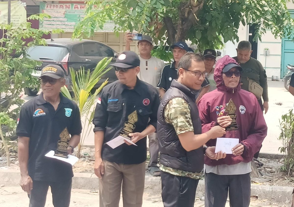 Ketua BPD Desa Sukadami, Akbar Jaeni (tengah, rompi hitam), menyerahkan penghargaan kepada peserta karnaval di Perumahan Bumi Cikarang Makmur (BCM), Kecamatan Cikarang Selatan, Kabupaten Bekasi, Minggu (23/8/2026), di sela penyampaian komitmen BPD mengawal Pilkades 2026 secara netral dan sesuai aturan.