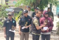 Ketua BPD Desa Sukadami, Akbar Jaeni (tengah, rompi hitam), menyerahkan penghargaan kepada peserta karnaval di Perumahan Bumi Cikarang Makmur (BCM), Kecamatan Cikarang Selatan, Kabupaten Bekasi, Minggu (23/8/2026), di sela penyampaian komitmen BPD mengawal Pilkades 2026 secara netral dan sesuai aturan.