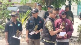 Ketua BPD Desa Sukadami, Akbar Jaeni (tengah, rompi hitam), menyerahkan penghargaan kepada peserta karnaval di Perumahan Bumi Cikarang Makmur (BCM), Kecamatan Cikarang Selatan, Kabupaten Bekasi, Minggu (23/8/2026), di sela penyampaian komitmen BPD mengawal Pilkades 2026 secara netral dan sesuai aturan.