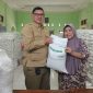 Kepala Desa Muktiwari, Bahrudin, SE, secara simbolis menyerahkan bantuan pangan berupa beras medium 10 kilogram kepada salah satu Keluarga Penerima Manfaat (KPM) di Aula Desa Muktiwari, Kecamatan Cibitung, Kabupaten Bekasi, Senin (24/8/2026). Sebanyak 1.902 KPM menerima bantuan 30 kilogram beras per KK melalui Program Bantuan Pangan Pemerintah Pusat yang disalurkan oleh Perum Bulog.
