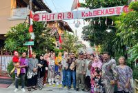 Warga RT 02 RW 013, Kelurahan Jatimulya, Kecamatan Tambun Selatan, bersama Lurah Jatimulya Acep Abdi Eka Pradana berfoto bersama di depan gapura lingkungan usai mengikuti peninjauan Lomba Gang dalam rangka menyemarakkan HUT ke-81 Kemerdekaan RI dan Hari Jadi Kabupaten Bekasi ke-76, Minggu (16/8/2026).