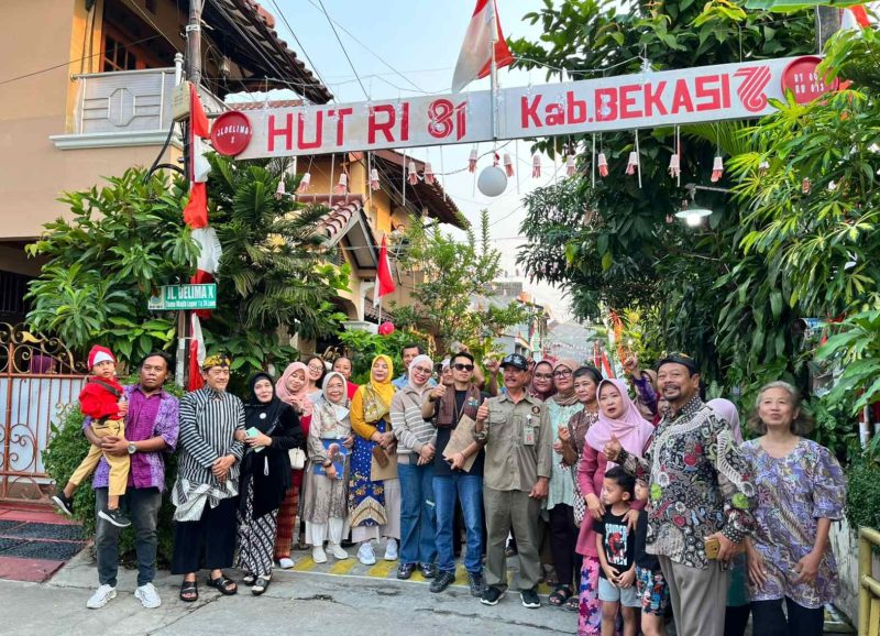 Warga RT 02 RW 013, Kelurahan Jatimulya, Kecamatan Tambun Selatan, bersama Lurah Jatimulya Acep Abdi Eka Pradana berfoto bersama di depan gapura lingkungan usai mengikuti peninjauan Lomba Gang dalam rangka menyemarakkan HUT ke-81 Kemerdekaan RI dan Hari Jadi Kabupaten Bekasi ke-76, Minggu (16/8/2026).