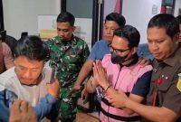 Tersangka AEZ mengenakan rompi tahanan berwarna pink dan dikawal petugas Kejaksaan Negeri Kabupaten Bekasi saat keluar usai menjalani pemeriksaan, Senin (10/8/2026). AEZ kemudian dibawa ke Lapas Kelas IIA Cikarang untuk menjalani penahanan selama 20 hari dalam perkara dugaan korupsi sambungan langganan Perumda Tirta Bhagasasi.