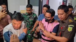 Tersangka AEZ mengenakan rompi tahanan berwarna pink dan dikawal petugas Kejaksaan Negeri Kabupaten Bekasi saat keluar usai menjalani pemeriksaan, Senin (10/8/2026). AEZ kemudian dibawa ke Lapas Kelas IIA Cikarang untuk menjalani penahanan selama 20 hari dalam perkara dugaan korupsi sambungan langganan Perumda Tirta Bhagasasi.