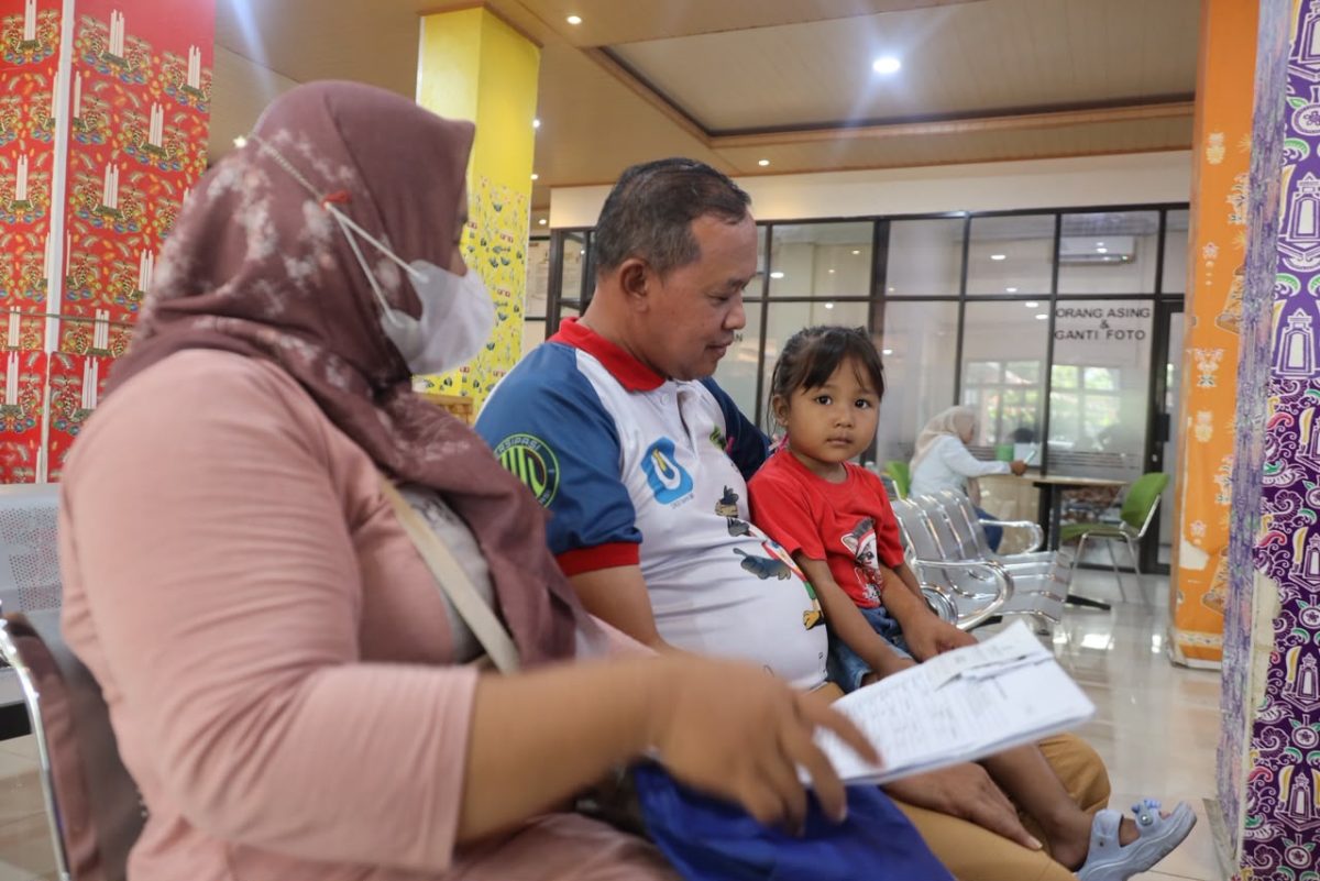 Seorang warga bersama suami dan anak mengikuti proses pelayanan di salah satu fasilitas pelayanan publik di Kota Bekasi. Pemerintah Kota Bekasi mengajak masyarakat melaporkan setiap dugaan pungutan tidak resmi dalam pelayanan publik.