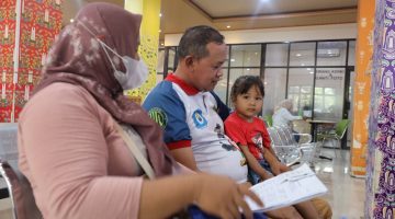 Seorang warga bersama suami dan anak mengikuti proses pelayanan di salah satu fasilitas pelayanan publik di Kota Bekasi. Pemerintah Kota Bekasi mengajak masyarakat melaporkan setiap dugaan pungutan tidak resmi dalam pelayanan publik.