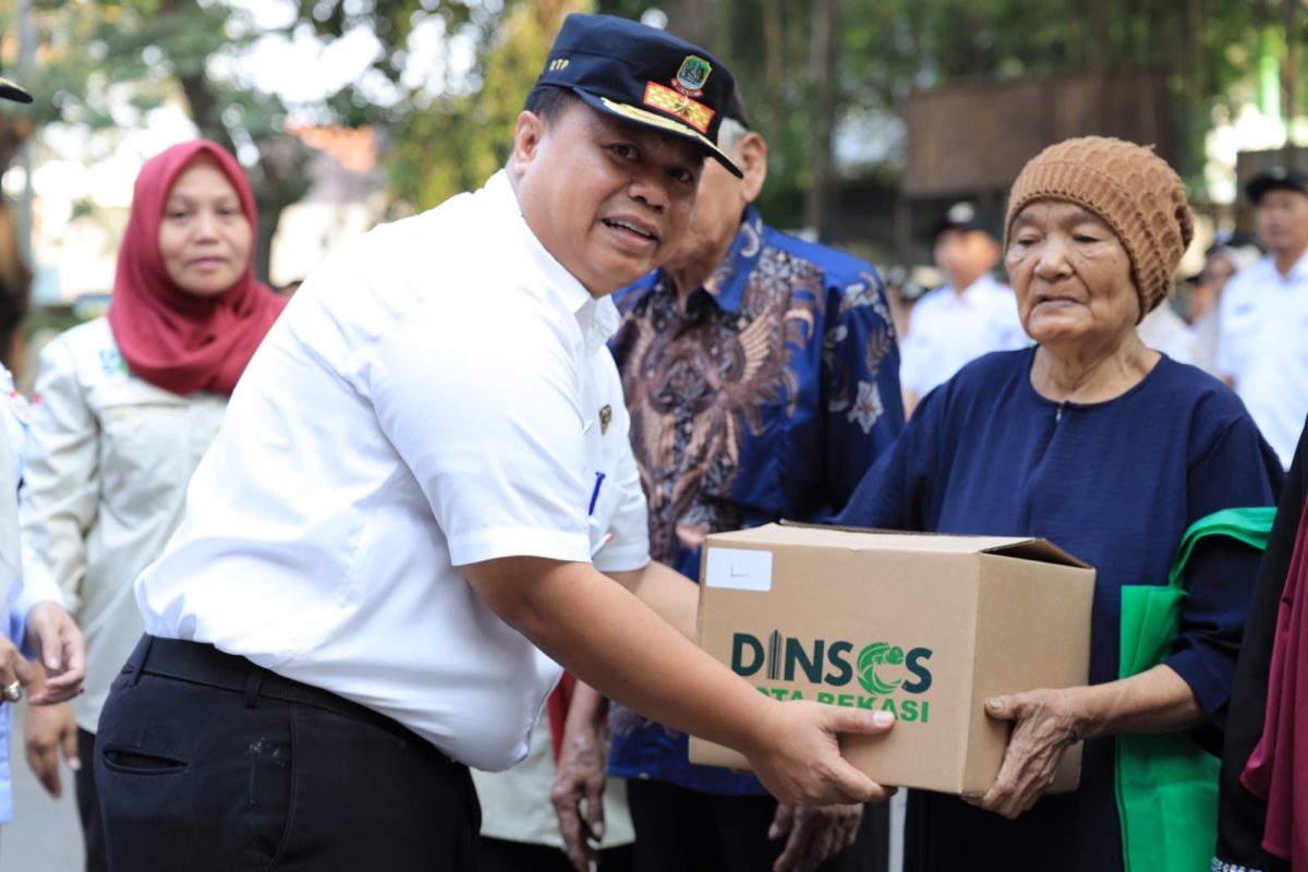 Kepala Dinas Sosial Kota Bekasi Robert Siagian menyerahkan bantuan permakanan kepada seorang warga lanjut usia dalam kegiatan Pendistribusian Permakanan Tahun 2026 di Kecamatan Bekasi Timur, Kota Bekasi, Rabu (16/9/2026). Program tersebut menyasar anak, lansia, dan penyandang disabilitas sebagai bagian dari upaya pemenuhan kebutuhan pangan kelompok rentan.