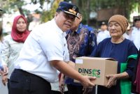 Kepala Dinas Sosial Kota Bekasi Robert Siagian menyerahkan bantuan permakanan kepada seorang warga lanjut usia dalam kegiatan Pendistribusian Permakanan Tahun 2026 di Kecamatan Bekasi Timur, Kota Bekasi, Rabu (16/9/2026). Program tersebut menyasar anak, lansia, dan penyandang disabilitas sebagai bagian dari upaya pemenuhan kebutuhan pangan kelompok rentan.